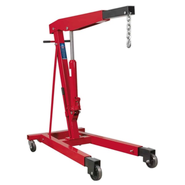 Heavy-duty red engine hoist with hydraulic lift and chain, suitable for automotive repairs and engine installations.