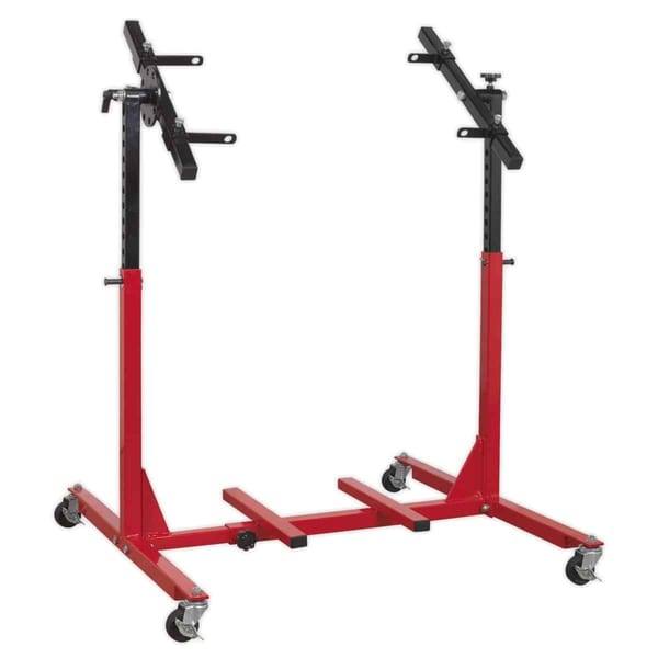 Adjustable red engine stand with wheels and support arms for engine maintenance and repair tasks.