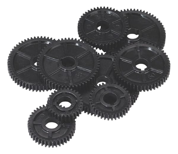 A collection of assorted black plastic gears in various sizes, showcasing intricate teeth and central holes for mechanical applications.